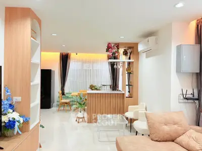 Spacious modern living room with stylish decor and open layout, featuring cozy seating and elegant lighting.