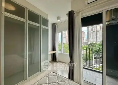 Modern bedroom with large windows and balcony view in urban apartment