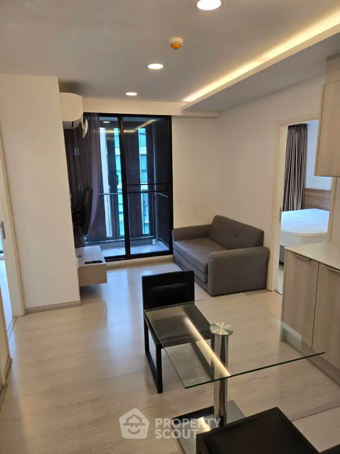 Modern living room with glass dining table and balcony view in a stylish apartment.