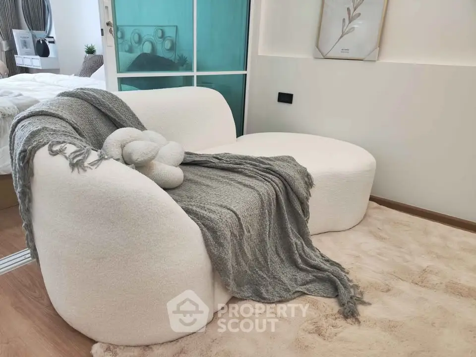 Cozy modern living room with plush white sofa and soft gray throw blanket