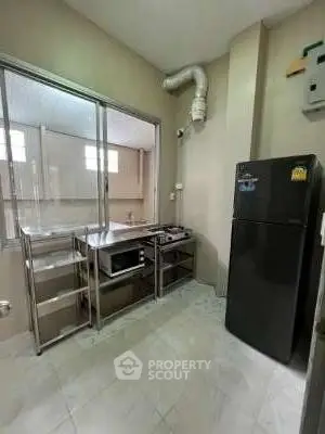 Modern kitchen with stainless steel shelves and black refrigerator
