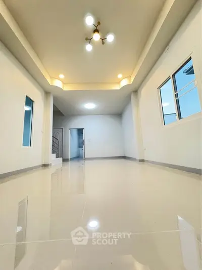 Spacious modern living room with elegant lighting and glossy tiled flooring.