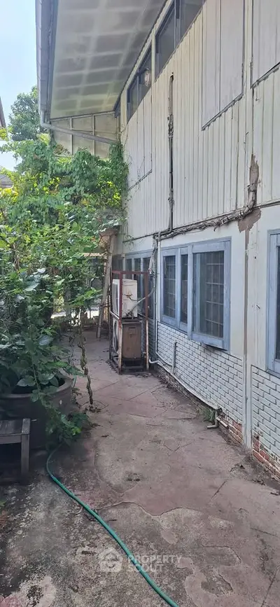 Charming rustic exterior with lush greenery and vintage charm, perfect for renovation enthusiasts.