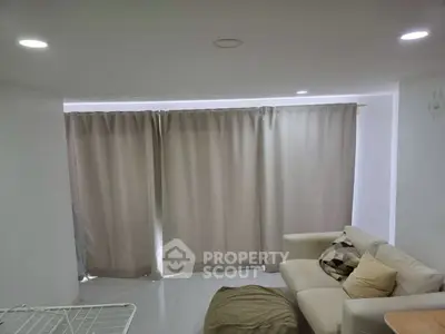 Cozy living room with modern sofa and neutral curtains