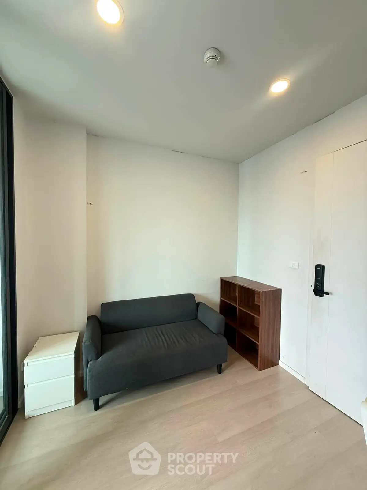 Cozy corner unit with modern sofa and bookshelf, perfect for a small living space.