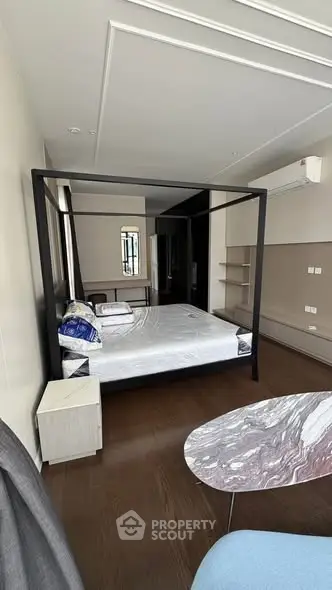 Spacious bedroom with modern four-poster bed and elegant decor