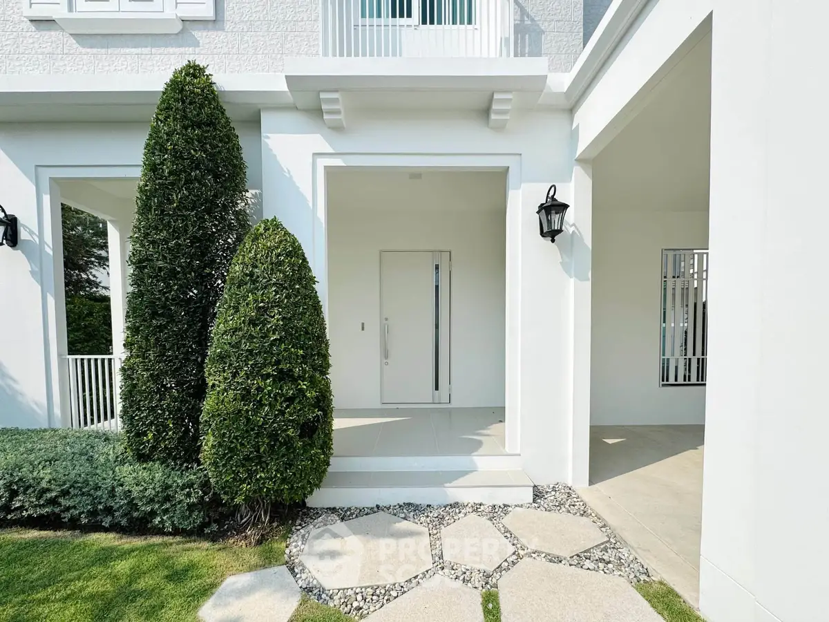 Elegant modern home entrance with manicured shrubs and stylish lighting