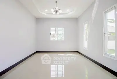 Spacious empty room with elegant chandelier and glossy tiled floor