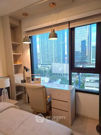 Modern bedroom with city view, featuring a cozy workspace and stylish lighting.