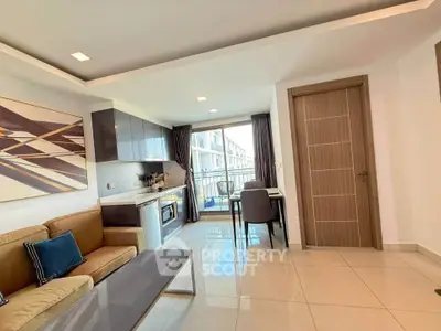 Modern living room with open kitchen and balcony view in stylish apartment.