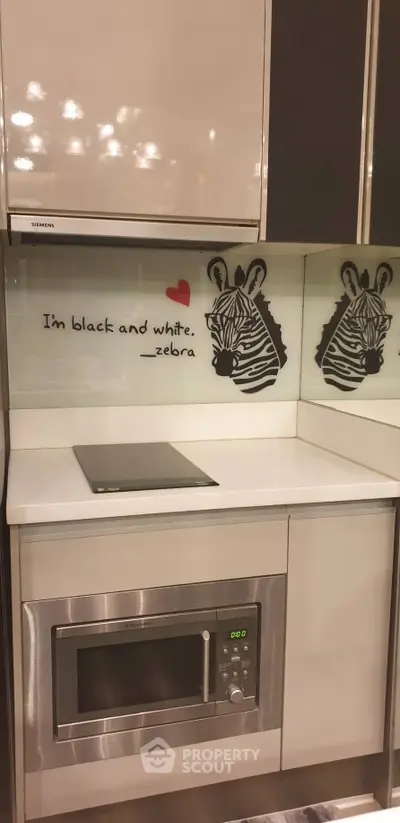 Modern kitchen corner with zebra-themed backsplash and built-in microwave.