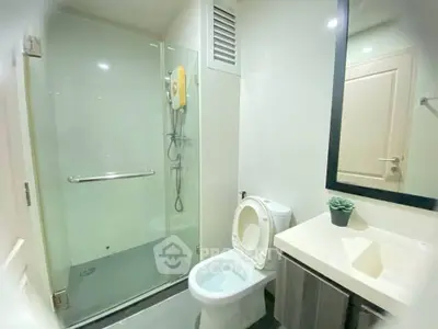 Modern bathroom with glass shower and sleek vanity in a contemporary home.