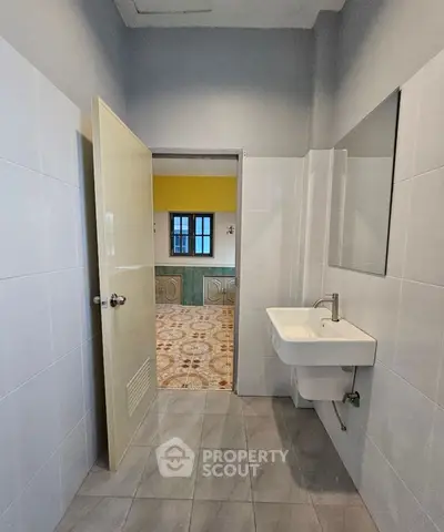 Modern bathroom with sleek sink and view into colorful room