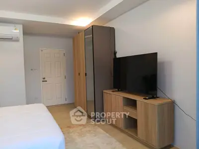 Modern bedroom with sleek furniture and large TV setup