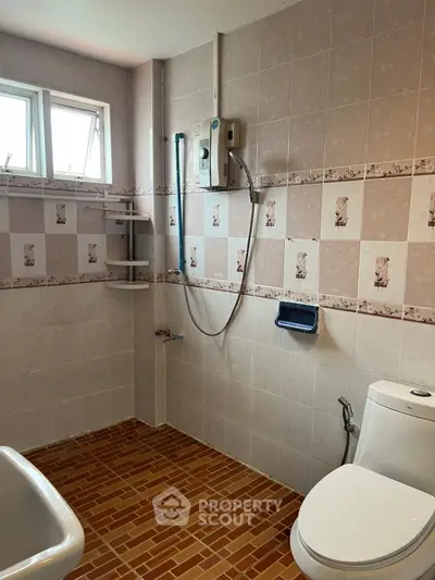 Charming bathroom with tiled walls and modern fixtures, perfect for a cozy home.