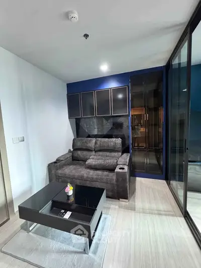 Modern living room with sleek furniture and glass partition in contemporary apartment.