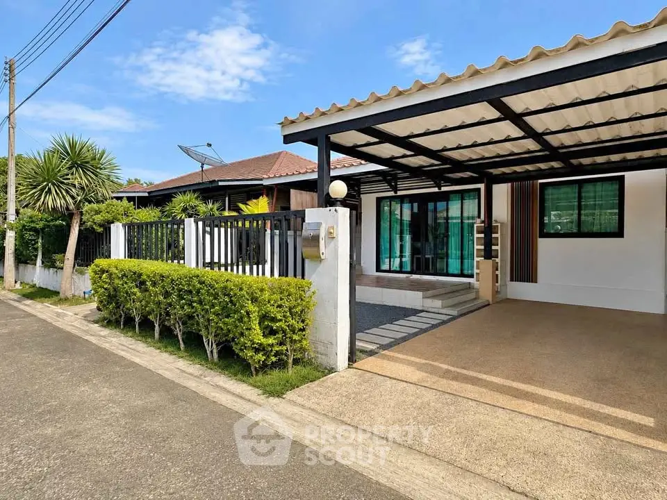 Charming single-story home with carport and lush greenery in a serene neighborhood.