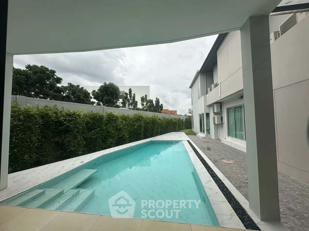 Luxurious modern home with private pool and lush greenery, perfect for relaxation and entertainment.