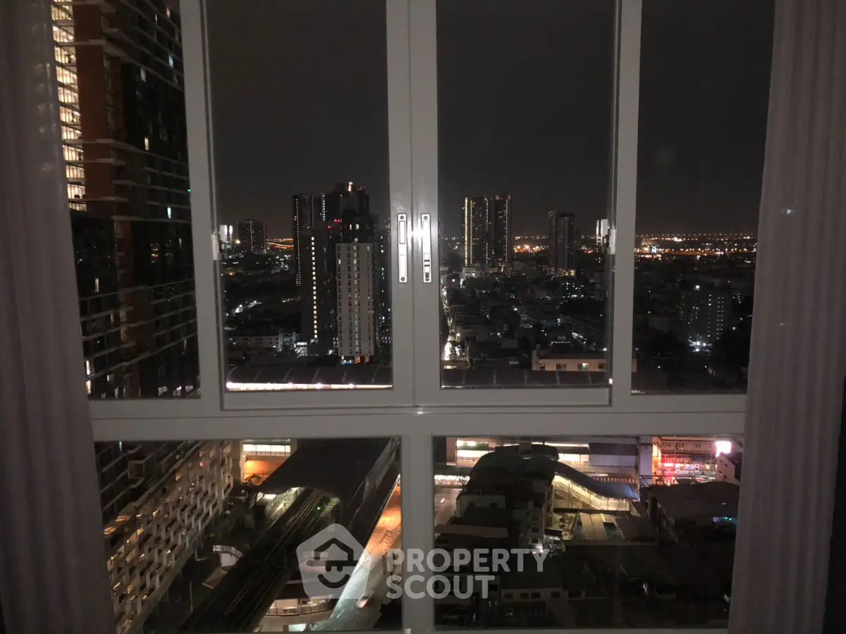 Stunning cityscape view from high-rise apartment window at night, showcasing vibrant urban lights.