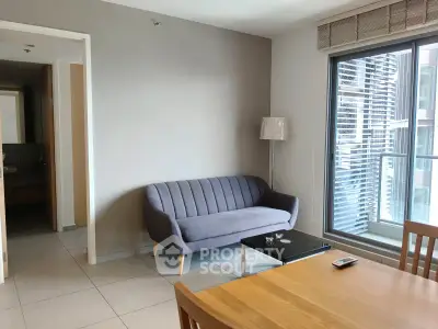 Modern living room with sleek sofa and large window in a stylish apartment.