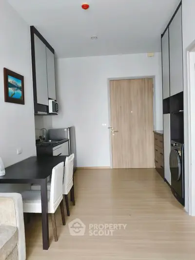 Modern compact kitchen with dining area and washing machine in sleek apartment