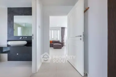 Modern interior hallway leading to a spacious living room with stylish decor.