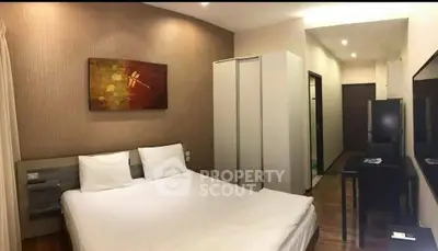 Modern bedroom with stylish decor and ample storage in a cozy apartment.