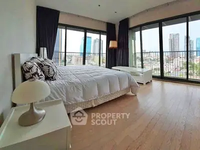 Spacious bedroom with city view and large windows in modern apartment