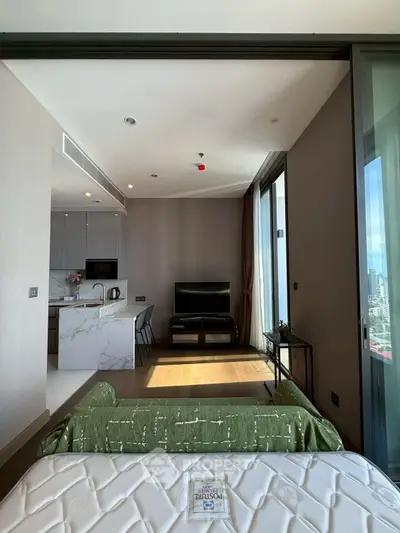 Modern apartment interior with open kitchen and living area, featuring sleek design and city view.
