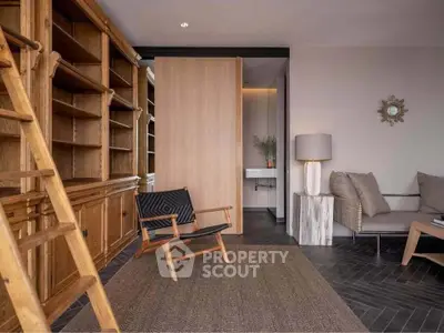 Chic study room with wooden bookshelves and modern seating in a stylish home.