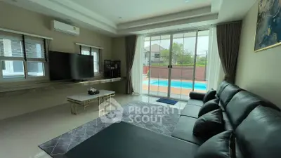 Luxurious living room with pool view, modern furnishings, and ample natural light.
