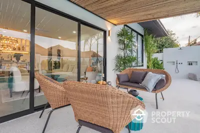 Stylish outdoor patio with cozy seating and modern glass doors leading to elegant living room.