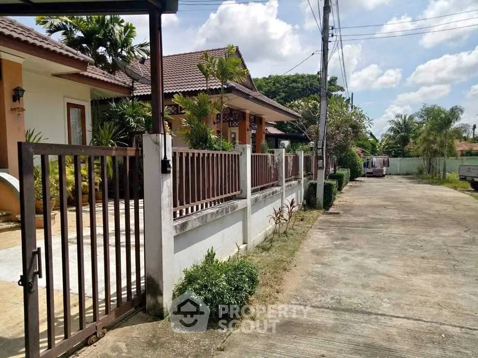 Charming suburban house with gated entrance and lush greenery, perfect for family living.