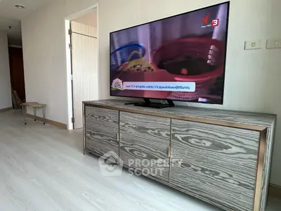 Modern living room with stylish wooden TV stand and flat-screen television.