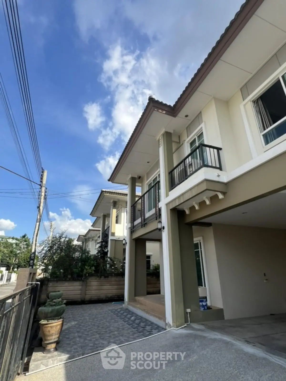 Modern two-story house with spacious driveway and elegant balcony