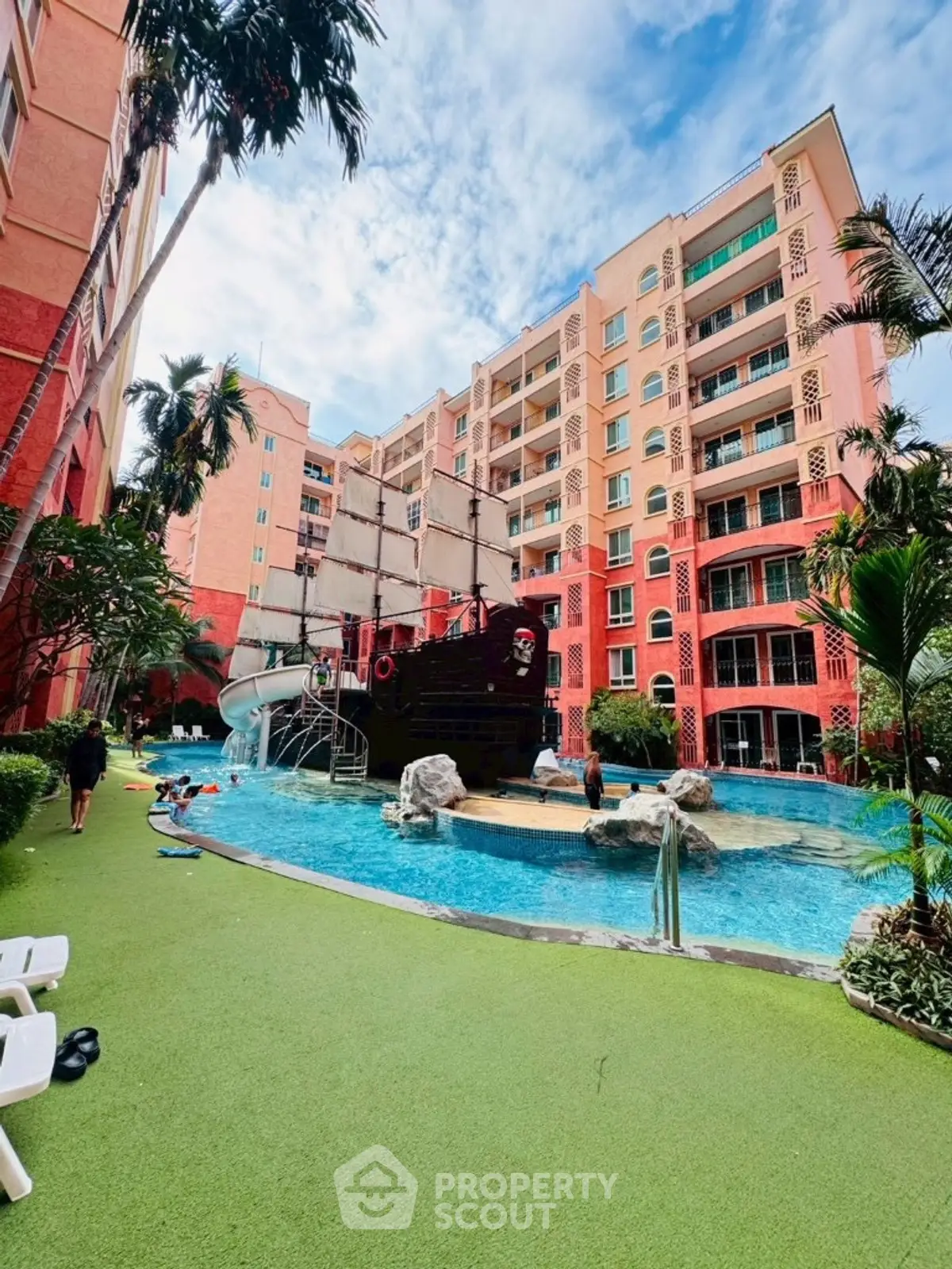 Luxurious resort-style pool with pirate ship feature in vibrant residential complex.