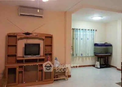 Cozy living room with vintage TV stand and fish tank, perfect for relaxation.