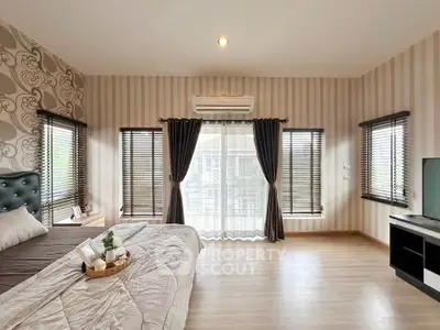 Spacious modern bedroom with elegant decor and large windows for natural light.