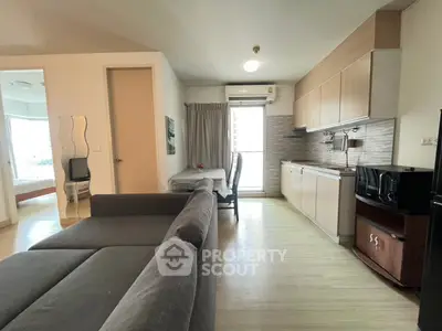 Modern open-plan living room and kitchen with stylish furniture and natural light.