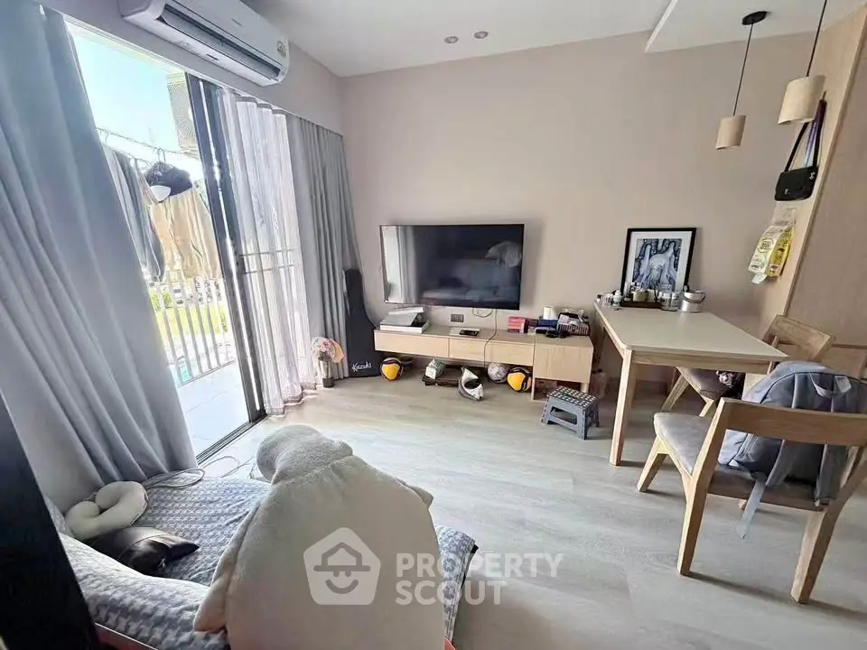 Cozy living room with modern decor and balcony access, perfect for relaxation and entertainment.