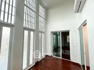 Spacious modern living room with high ceilings and large windows, perfect for natural light.