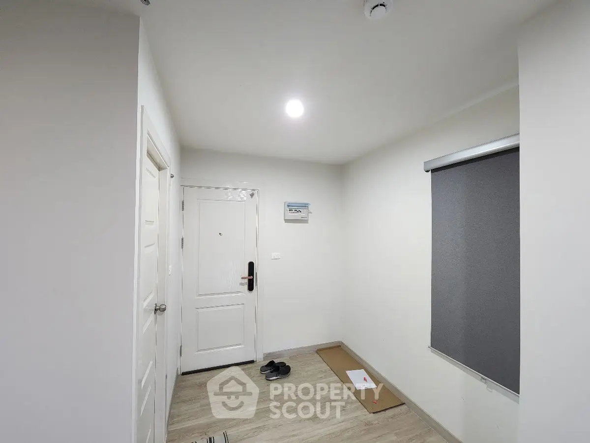 Minimalist apartment entrance with white door and wooden flooring