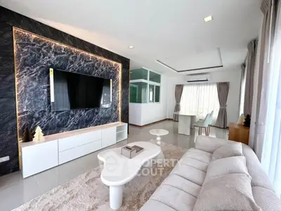 Luxurious modern living room with stylish decor and large TV, perfect for relaxation and entertainment.