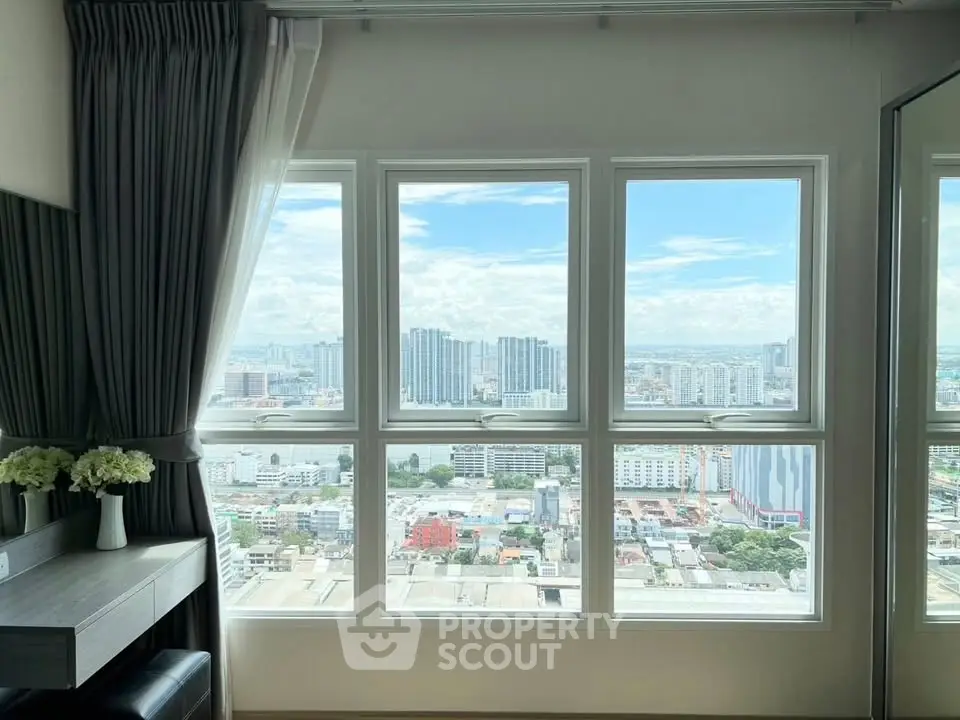 Stunning cityscape view from a modern apartment window, showcasing urban skyline and bright blue skies.