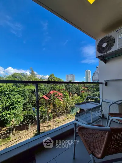 Charming balcony with lush greenery and city skyline view, perfect for relaxation.