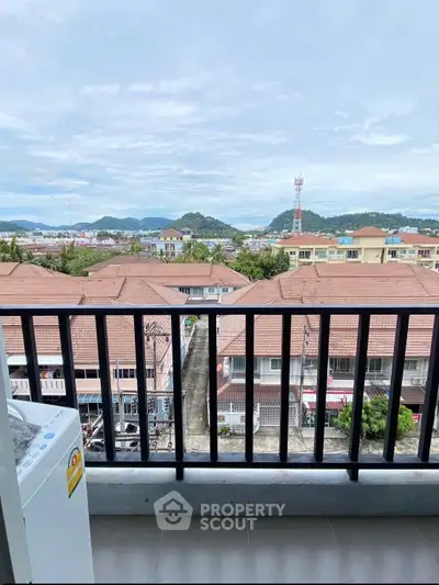 Charming balcony view overlooking rooftops and distant hills, perfect for serene mornings.
