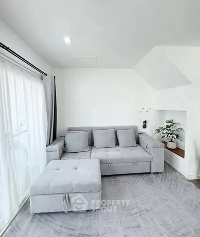 Modern living room with sleek gray sofa and natural light