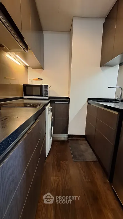 Modern kitchen with sleek cabinetry and built-in appliances in a compact layout.