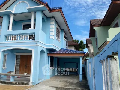 Charming blue two-story house with balcony and spacious driveway