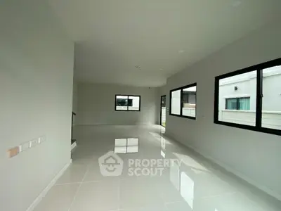 Spacious modern living room with large windows and glossy tiled floor